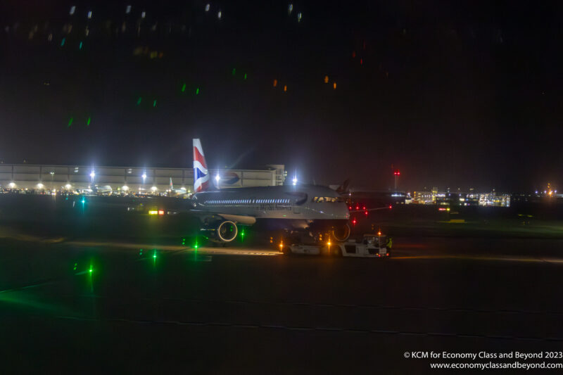 British Airways Airbus A320 being towed at Heathrow Airport at night