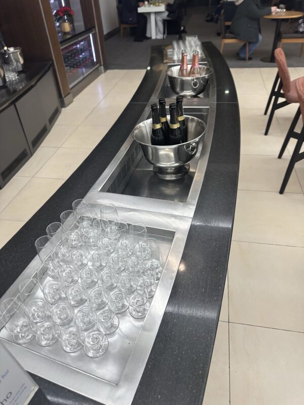 a row of wine glasses and bottles on a counter