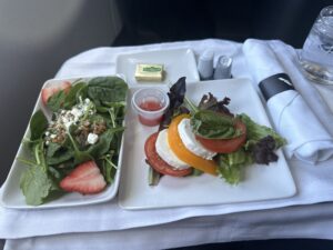 a plate of salad and cheese on a table