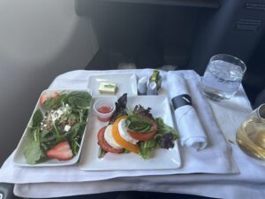a plate of salad and a glass of water on a table