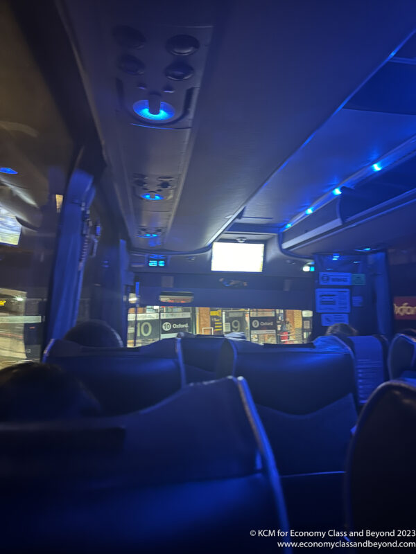 inside a bus with seats and a television