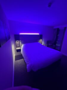 a bed in a room with purple lighting