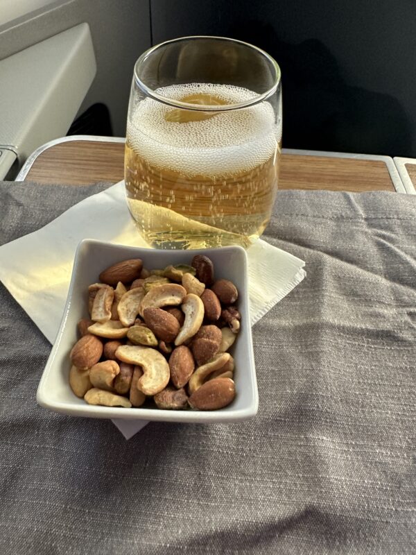 a bowl of nuts and a glass of beer