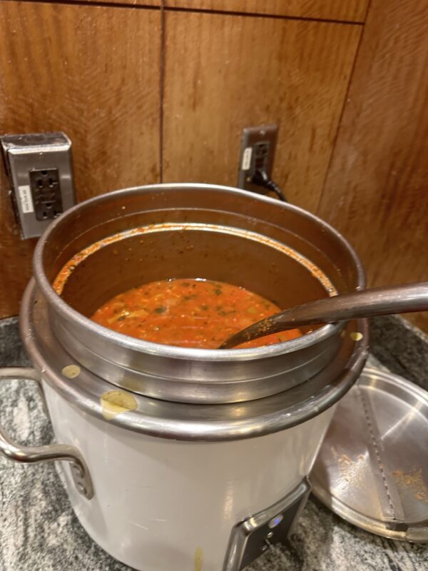 a pot of soup with a ladle