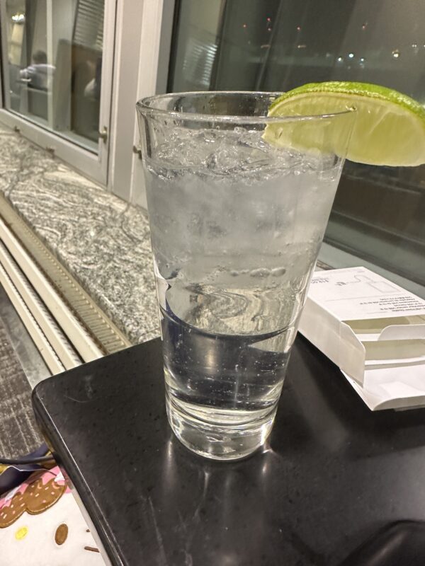 a glass of water with a lime wedge on a black surface