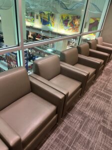 a row of brown leather chairs in a room with windows