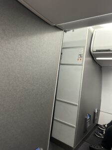 a grey wall with a white shelf