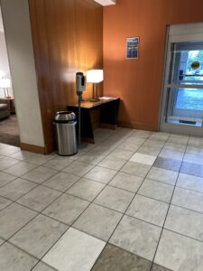 a room with a desk and trash can