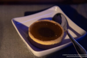 a small white plate with a small round pastry with a spoon