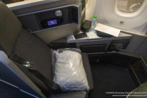 a seat with a bag and a bottle of water on the side of it