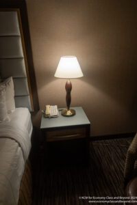 a lamp on a table next to a bed