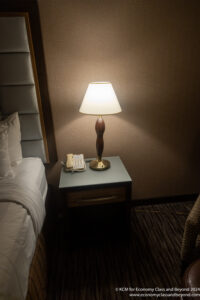 a lamp on a table next to a bed
