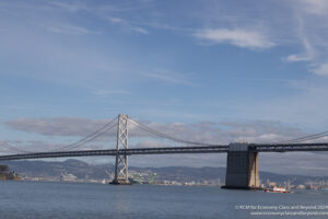 a bridge over water with a city in the background