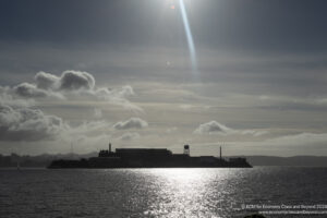 a body of water with buildings and clouds in the sky