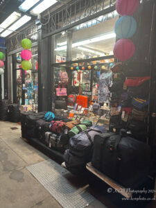 a storefront with bags and lanterns