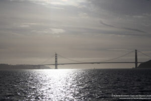 a bridge over water with a body of water and a cloudy sky