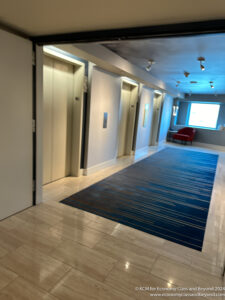 a hallway with elevator doors and a blue rug