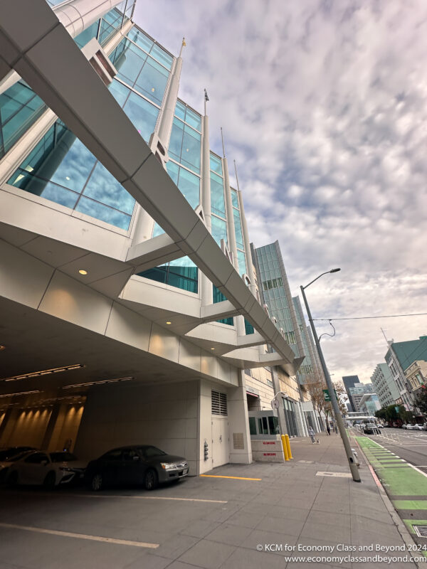 a building with a parking garage and cars parked on the side of the road