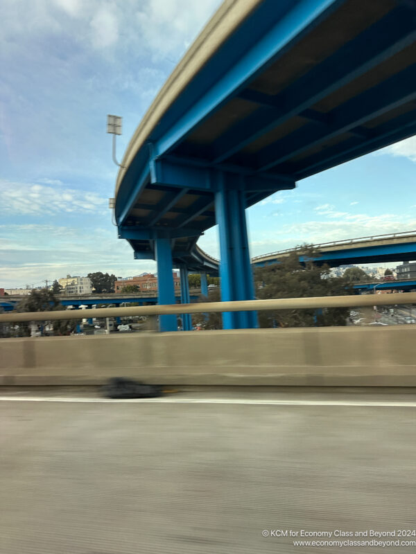 a blue bridge over a highway