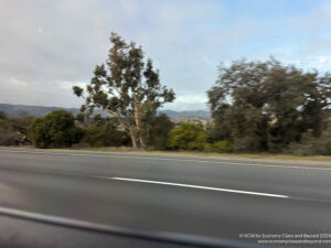 a road with trees and mountains in the background