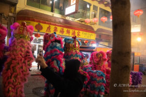 a person taking a picture of a group of colorful lion dance