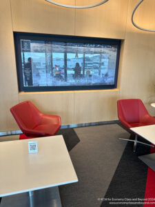 a room with red chairs and a tv on the wall