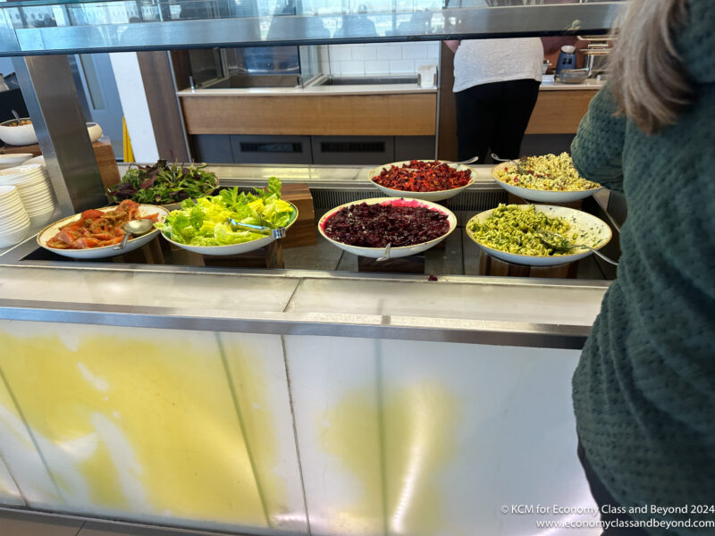 a group of bowls of food in a buffet