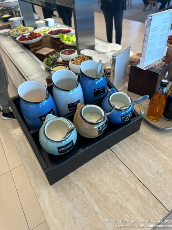 a group of blue and white ceramic containers with spoons on a table