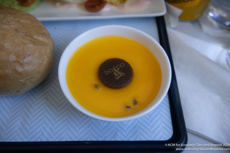 a bowl of orange liquid with a brown round object in it