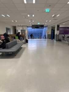 people sitting on benches in a large airport