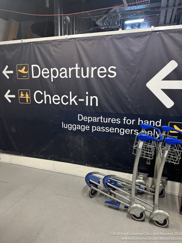 luggage carts next to a sign