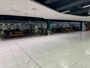 a large room with many people sitting on benches