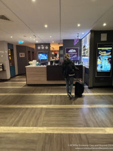 a woman walking with luggage in a hotel lobby