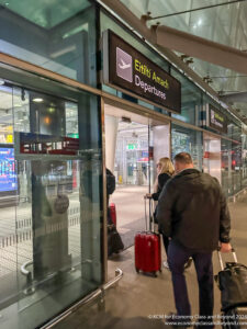 a man and woman with luggage in front of a glass building