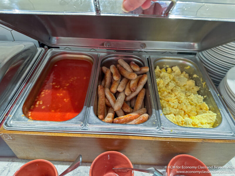 a tray of food with sausages and eggs