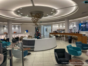 a room with a christmas tree and chairs