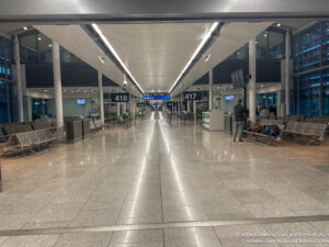 a large airport terminal with people walking and waiting area