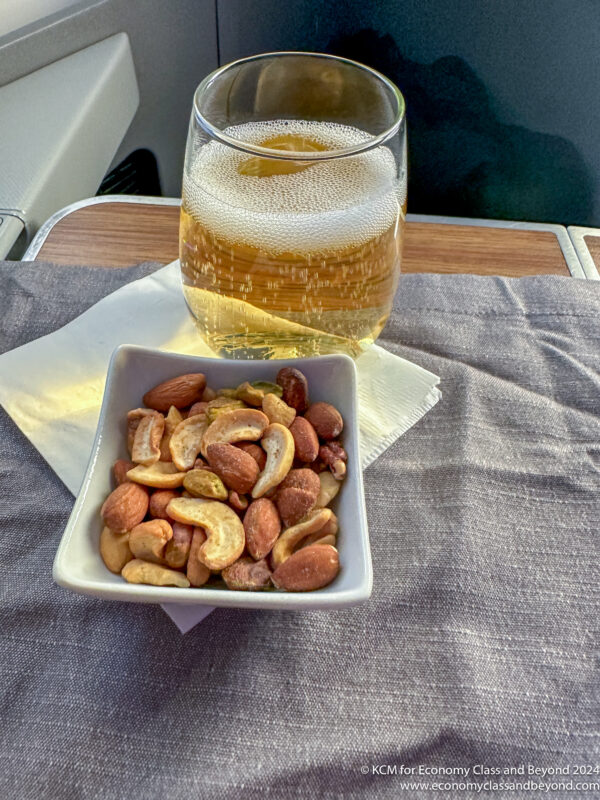 a bowl of nuts and a glass of beer