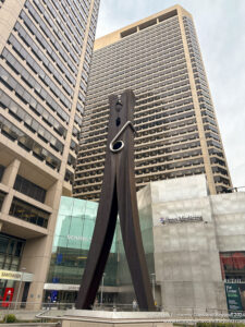 a large wooden sculpture in front of a tall building