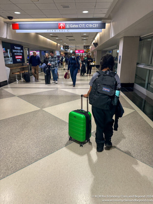 a person with a green suitcase in a airport