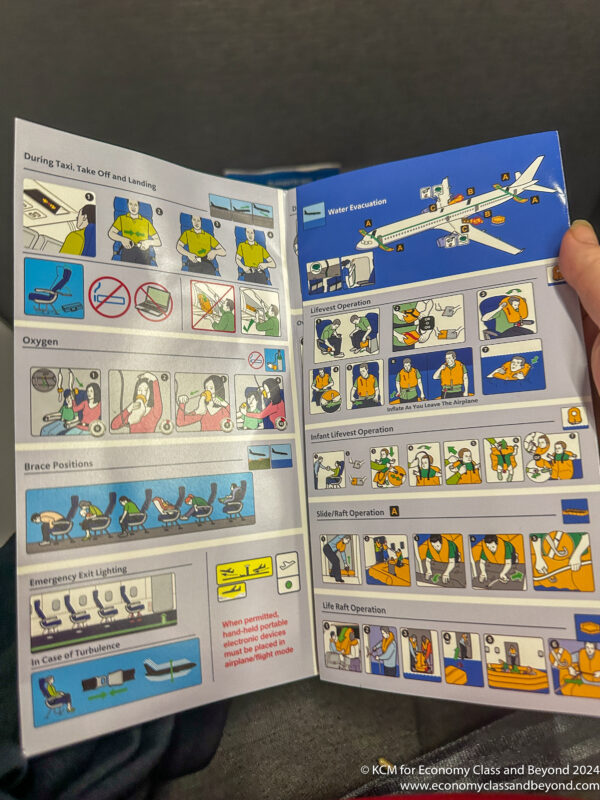 a hand holding an airplane instruction booklet