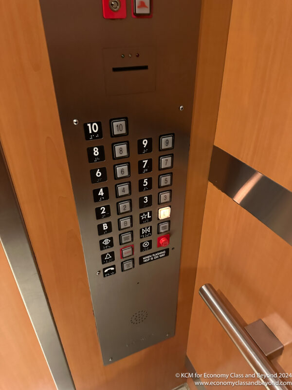 a elevator panel with buttons and a coin slot