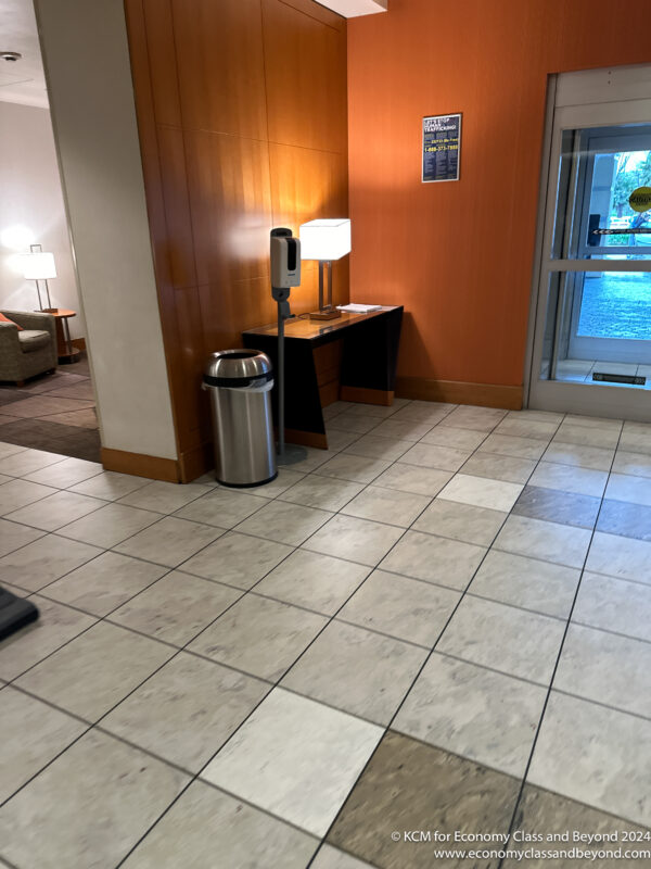 a room with a desk and a trash can