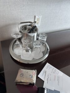 a tray of wine glasses and tongs on a table