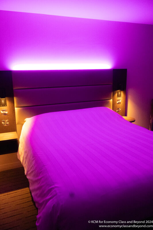 a bed with purple light