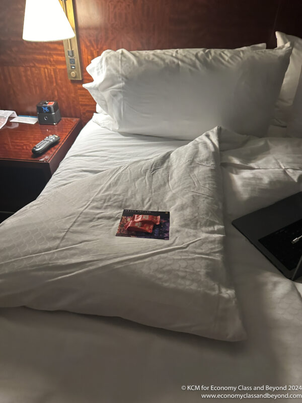 a bed with a laptop and a packet of candy on it