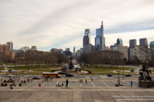 a city with a statue and people walking in the middle
