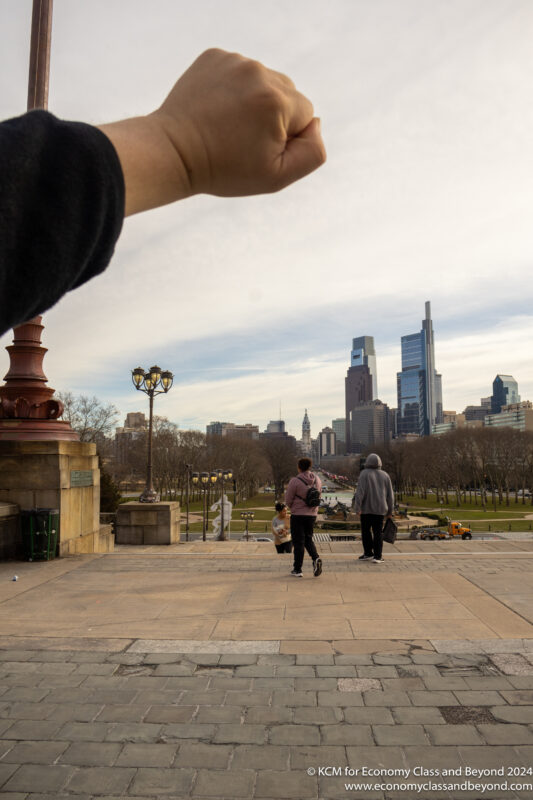 a person's hand pointing at a city