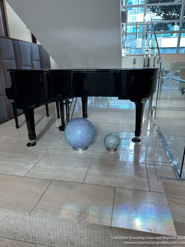a black piano with silver balls on the floor
