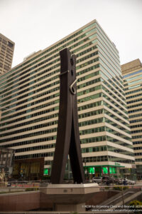 a large wooden sculpture in front of a tall building